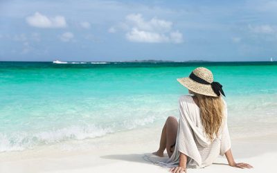 woman sitting on the shoreline at the beautiful beach
